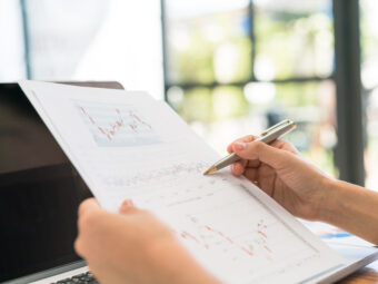 Business woman hand with Financial charts and laptop on the tabl